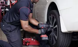 Tire technician removing a wheel to rotate a vehicle's tires